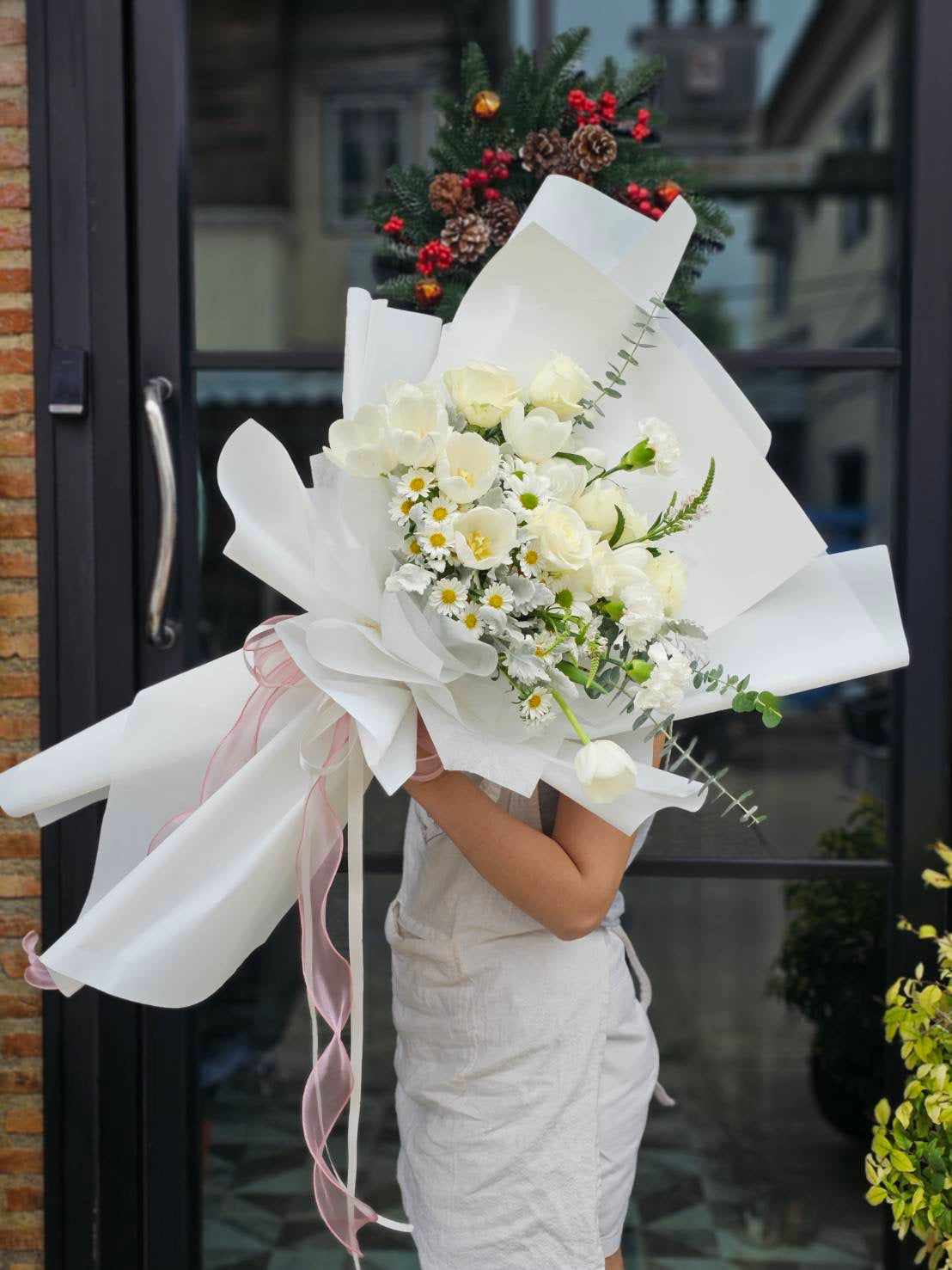 Bouquet of White Rose and White Tulips being held sideways